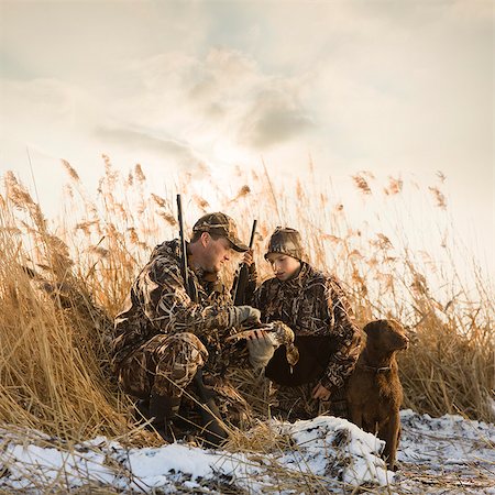 father and son duck hunting with their dog Stock Photo - Premium Royalty-Free, Code: 640-08089220