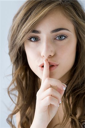 shhh - woman looking at camera Stock Photo - Premium Royalty-Free, Code: 640-08089687