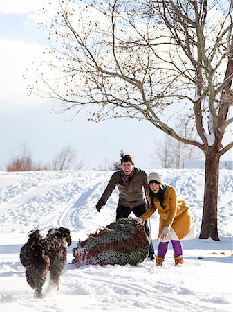 snow christmas tree white - young couple getting a christmas tree in the snow Stock Photo - Premium Royalty-Free, Code: 640-08089699