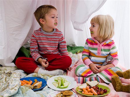 brother and sister in a makeshift fort eating lunch Stock Photo - Premium Royalty-Free, Code: 640-08089718