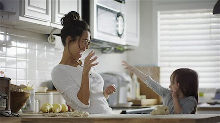 Playful mother and daughter baking and tossing dough in kitchen Photographie de stock - Premium Libres de Droits, Code: 640-09013402