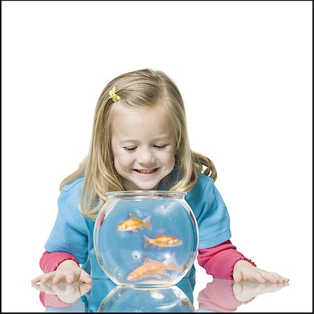 Close-up of a girl watching goldfish in a fishbowl Stock Photo - Premium Royalty-Free, Code: 640-01348712