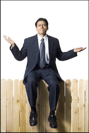 query - Businessman on wooden fence shrugging Stock Photo - Premium Royalty-Free, Code: 640-01348758