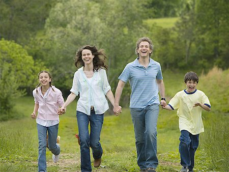 woman and a man with their son and daughter running in a field Stock Photo - Premium Royalty-Free, Code: 640-01348763