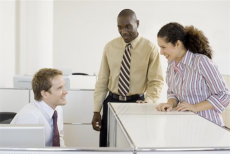 Three co-workers talking in an office Stock Photo - Premium Royalty-Free, Code: 640-01348820