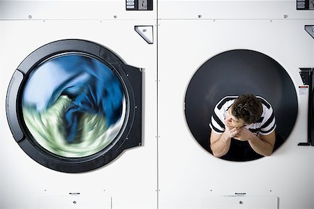 Man in dryer watching laundry Stock Photo - Premium Royalty-Free, Code: 640-01348847