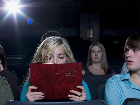 simsearch:640-02773406,k - Girl reading hardcover book at movie theater Stock Photo - Premium Royalty-Free, Code: 640-01348969