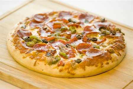 simsearch:640-01354413,k - High angle view of a pizza on a cutting board Foto de stock - Sin royalties Premium, Código: 640-01349124