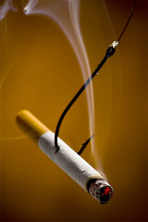 Close-up of a burning cigarette on a fishing hook Stock Photo - Premium Royalty-Free, Code: 640-01349148