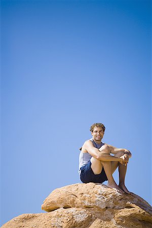 simsearch:640-01349238,k - Low angle view of a young man sitting on a rock Stock Photo - Premium Royalty-Free, Code: 640-01349281