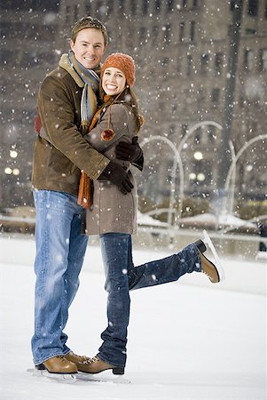 Couple embracing outdoors in winter with ice skates Stock Photo - Premium Royalty-Free, Code: 640-01349423