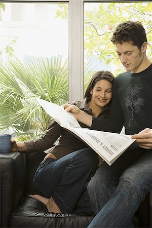Close-up of an adult couple reading a newspaper Stock Photo - Premium Royalty-Free, Code: 640-01349575