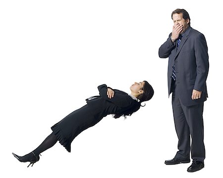Businesswoman levitating with businessman yawning Stock Photo - Premium Royalty-Free, Code: 640-01349572