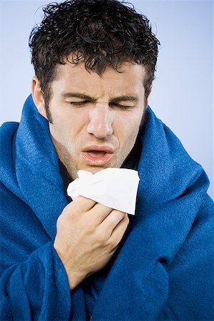 Man wrapped in blanket with tissue Stock Photo - Premium Royalty-Free, Code: 640-01349901