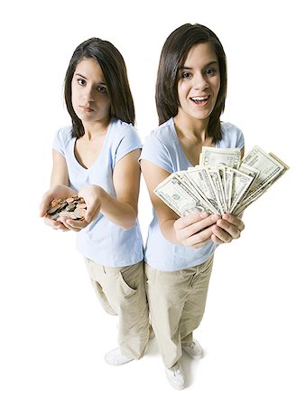 families wealthy - High angle view of two teenage girls holding American dollar bill and coins Stock Photo - Premium Royalty-Free, Code: 640-01354084