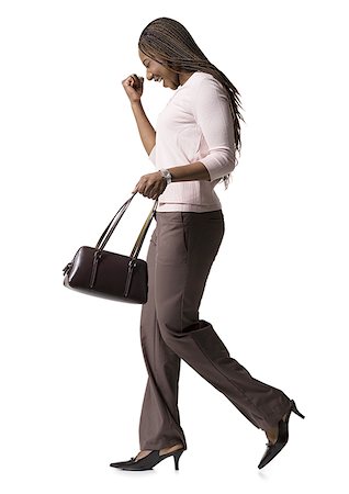 simsearch:640-01349238,k - Profile of a young woman walking with a hand bag Stock Photo - Premium Royalty-Free, Code: 640-01354320