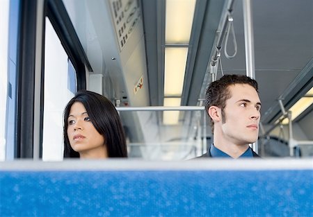 Low angle view of a young man and a young woman sitting in a train Stock Photo - Premium Royalty-Free, Code: 640-01354348
