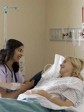 Profile of a female doctor examining the blood pressure of a female patient Stock Photo - Premium Royalty-Free, Code: 640-01354480