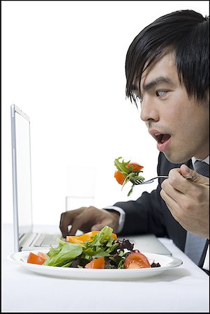 simsearch:640-01350815,k - Close-up of a businessman eating while using a laptop Stock Photo - Premium Royalty-Free, Code: 640-01354577