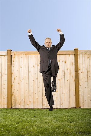 Low angle view of a businessman standing on one leg Stock Photo - Premium Royalty-Free, Code: 640-01354571