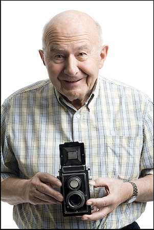 Portrait of a senior man holding a camera Stock Photo - Premium Royalty-Free, Code: 640-01355310