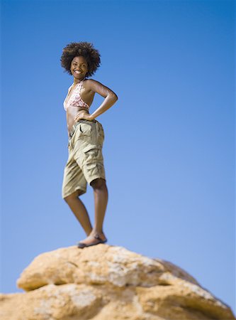 simsearch:640-01358229,k - Low angle view of a young woman standing on a rock Stock Photo - Premium Royalty-Free, Code: 640-01355365