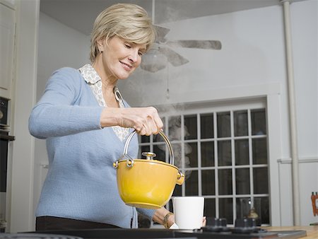 Low angle view of a mature woman pouring tea Stock Photo - Premium Royalty-Free, Code: 640-01355463
