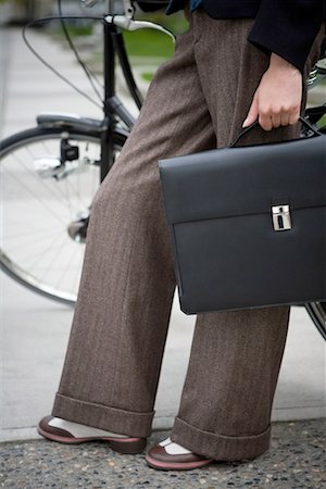 Low section view of a woman standing with a bicycle Stock Photo - Premium Royalty-Free, Code: 640-01355522