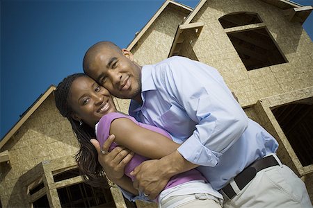 simsearch:640-02764709,k - Portrait of a young man embracing a young woman in front of an unfinished home Stock Photo - Premium Royalty-Free, Code: 640-01355612