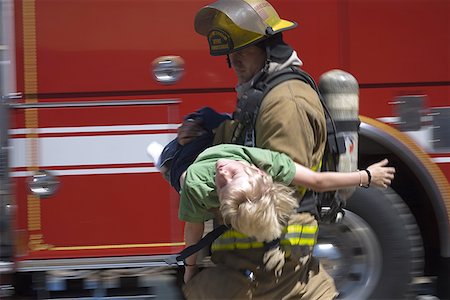 fire extinguisher - Profile of a firefighter carrying a boy Stock Photo - Premium Royalty-Free, Code: 640-01355690