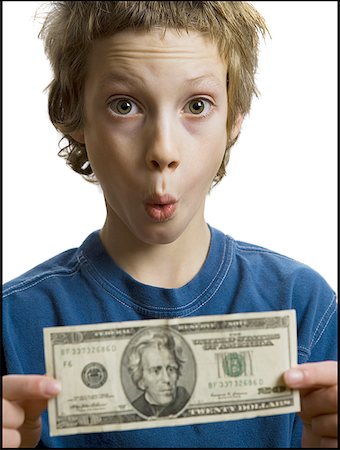 Portrait of a boy holding a twenty dollar bill Stock Photo - Premium Royalty-Free, Code: 640-01355834