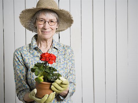simsearch:640-02768330,k - Portrait of an elderly woman holding a potted flower plant Stock Photo - Premium Royalty-Free, Code: 640-01355888