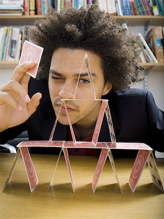 Close-up of a young man making a house of cards Stock Photo - Premium Royalty-Free, Code: 640-01355951