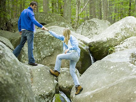 propulsion - Young man helping a young woman climb a rock Stock Photo - Premium Royalty-Free, Code: 640-01356166