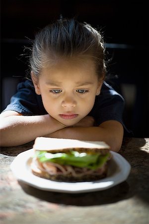 sad girls - Close-up of a girl looking at a sandwich in a plate Stock Photo - Premium Royalty-Free, Code: 640-01356505