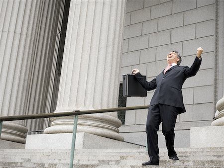 simsearch:640-01350504,k - Low angle view of a male lawyer laughing and walking down the steps of a courthouse Foto de stock - Sin royalties Premium, Código: 640-01356547