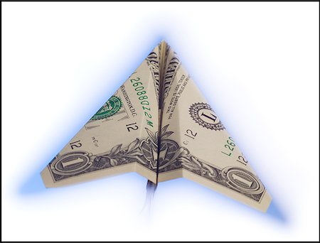 Close-up of a paper airplane made from a US dollar bill flying Stock Photo - Premium Royalty-Free, Code: 640-01356646