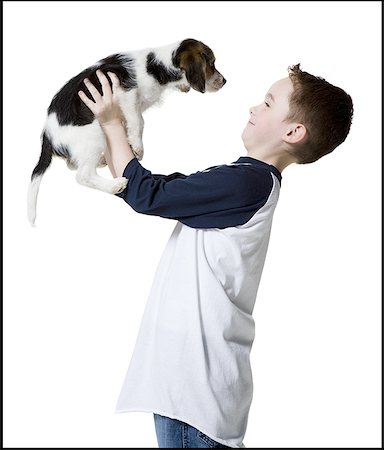 Profile of a boy holding a puppy Stock Photo - Premium Royalty-Free, Code: 640-01356750