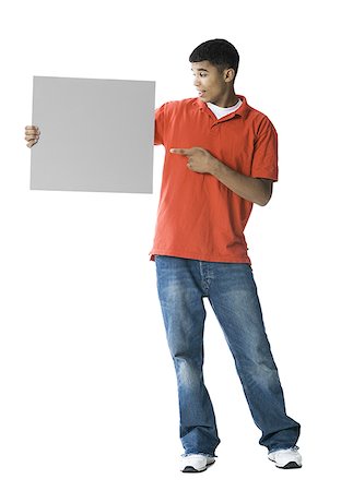 Young man pointing towards a blank sign Stock Photo - Premium Royalty-Free, Code: 640-01356873