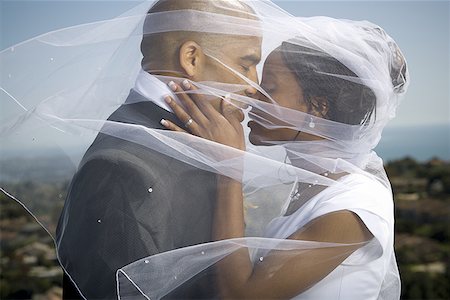 Profile of a newlywed couple kissing each other under a veil Stock Photo - Premium Royalty-Free, Code: 640-01356883