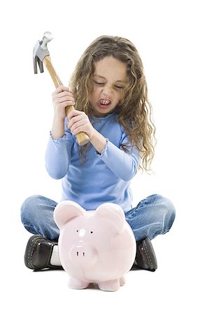 Close-up of a girl raising a hammer to hit a piggy bank Stock Photo - Premium Royalty-Free, Code: 640-01356921