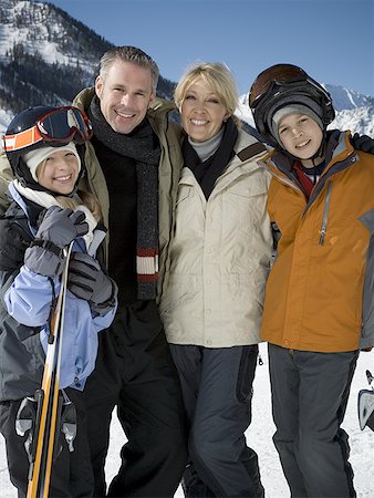 Portrait of a mid adult couple and their children holding skis Stock Photo - Premium Royalty-Free, Code: 640-01357305