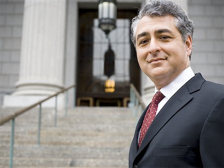 politician - Portrait of a man standing on the steps of a courthouse and smiling Stock Photo - Premium Royalty-Free, Code: 640-01357620