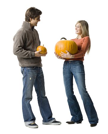Young couple standing face to face holding pumpkins Stock Photo - Premium Royalty-Free, Code: 640-01357657