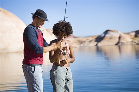 simsearch:640-01350537,k - Young man teaching a young woman how to fish Stock Photo - Premium Royalty-Free, Code: 640-01357674