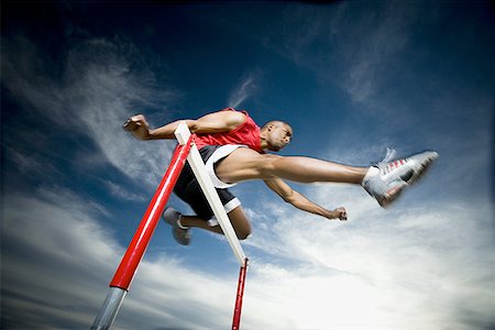 simsearch:640-01361005,k - Low angle view of a young man jumping over a hurdle in a race Stock Photo - Premium Royalty-Free, Code: 640-01357750