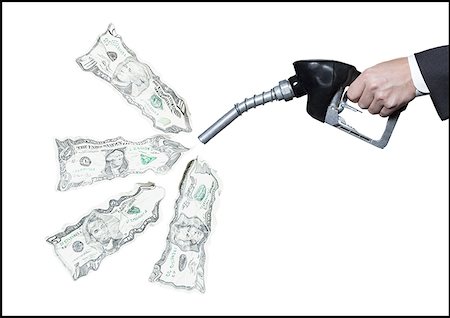 Close-up of a person's hand holding a fuel pump with dollar bills coming out of it Stock Photo - Premium Royalty-Free, Code: 640-01357870