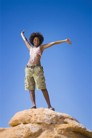 simsearch:640-01358229,k - Low angle view of a young woman standing on a rock Stock Photo - Premium Royalty-Free, Code: 640-01357976