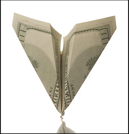 Close-up of a paper airplane made from one hundred dollar bill with damaged nose Stock Photo - Premium Royalty-Free, Code: 640-01358040