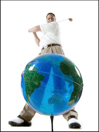 simsearch:640-01361005,k - Low angle view of a mid adult man hitting a globe with a golf club Stock Photo - Premium Royalty-Free, Code: 640-01358100